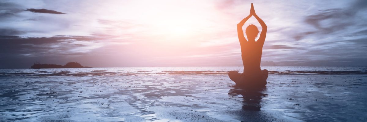 well being concept, beautiful sunset on the beach, woman practicing yoga
