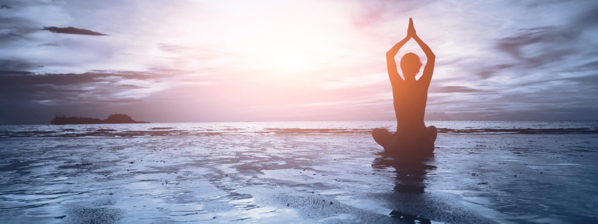 well being concept, beautiful sunset on the beach, woman practicing yoga